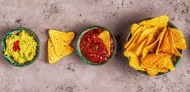 A bowl of salsa and some tortilla chips.